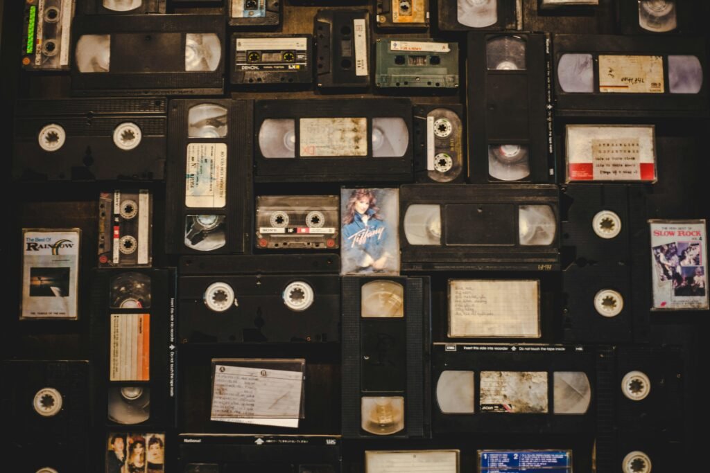 Top view of assorted vintage VHS tapes and cassettes in a nostalgic layout.